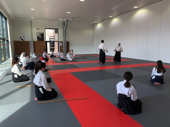 Le dojo pendant un cours enfants, pratiquants assis autour du tatami