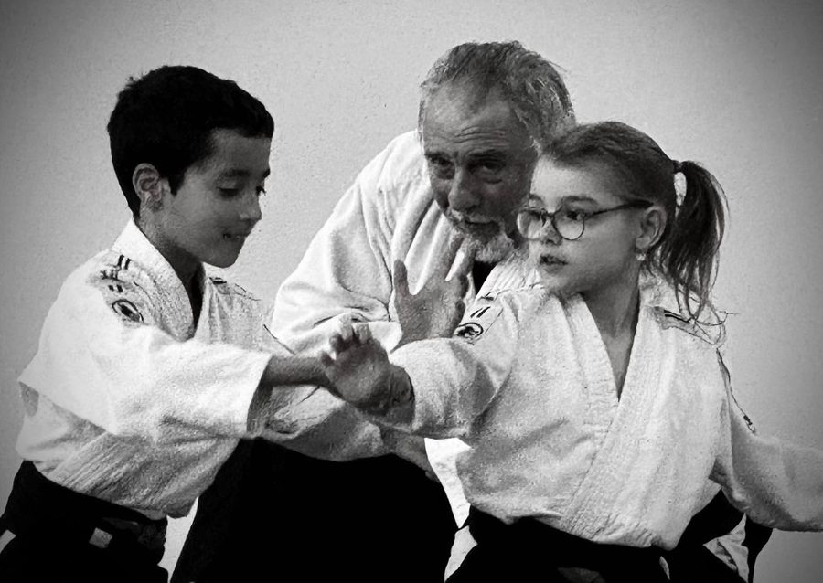 Un enseignant travaille avec deux jeunes élèves, photo noir et blanc