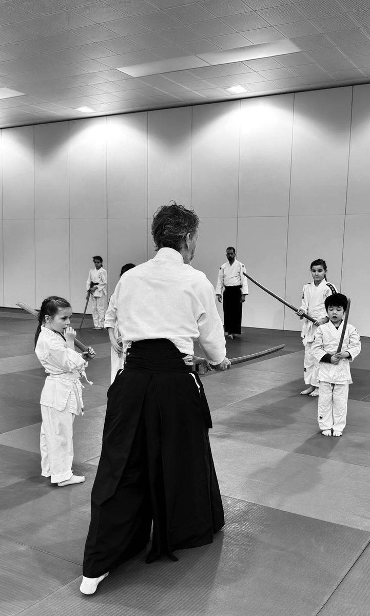 Jeune pratiquant au premier plan pendant le cours au dojo
