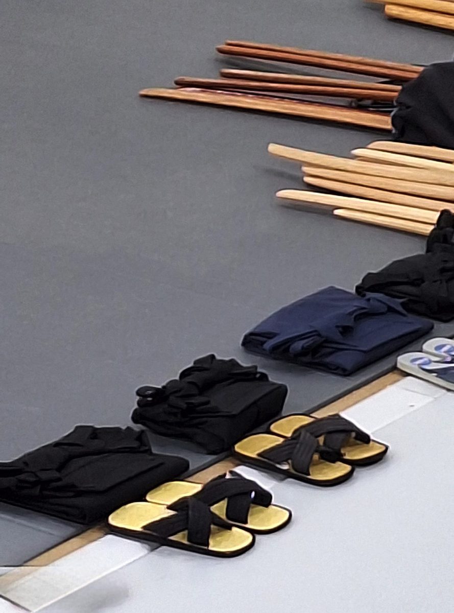 Armes en bois et tenues alignées au bord du tatami