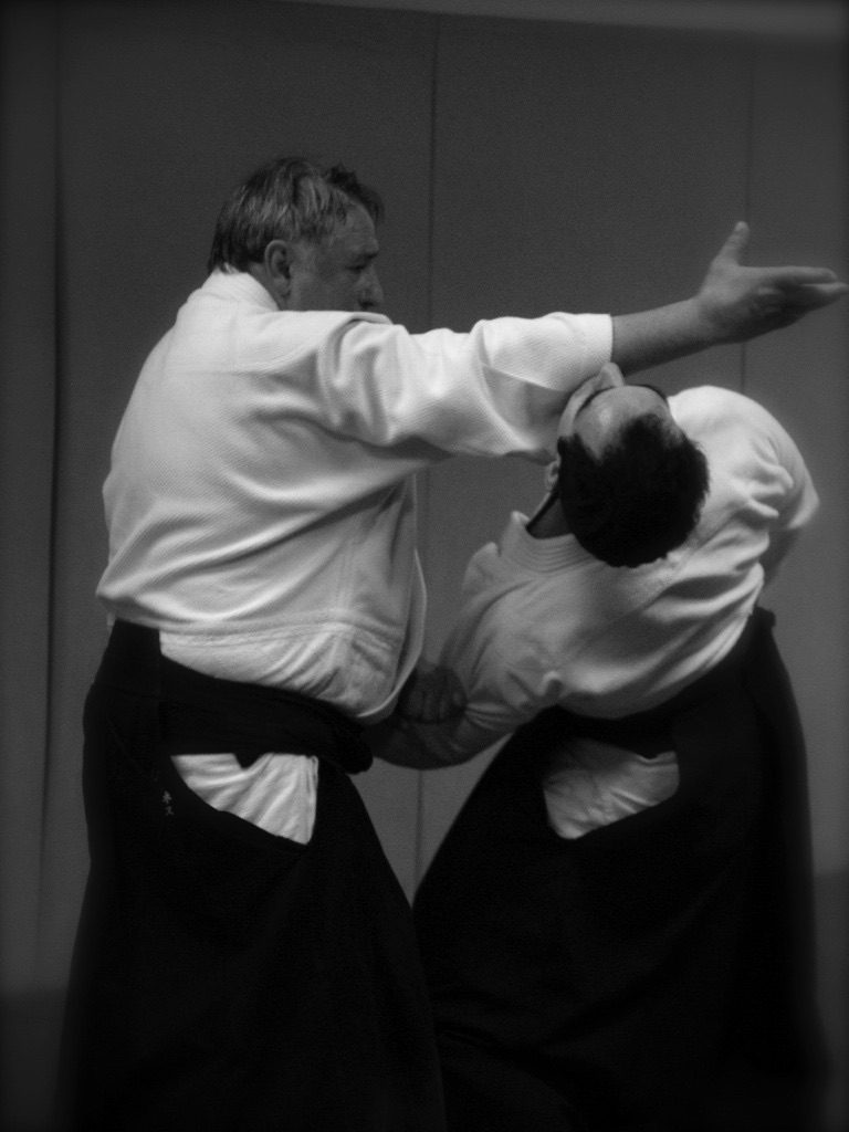 Démonstration devant les pratiquants assis, photo noir et blanc