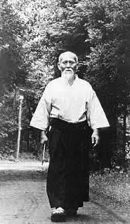 Morihei Ueshiba, fondateur de l'aïkido, marchant en tenue de pratique